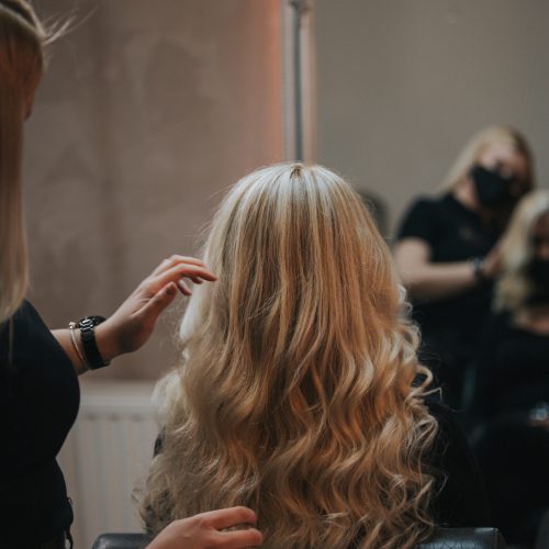 A blonde female getting a new hairstyle at a hair salon
