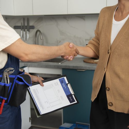 male-plumber-working-with-client-fix-kitchen-problems